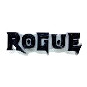 May include: Black 3D printed word "ROGUE" with a textured surface.