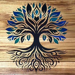 May include: A wooden artwork featuring a stylized tree design. The tree's trunk and roots are dark blue, with leaves in shades of blue and teal. The background is a light brown wood grain.