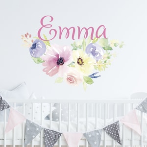 May include: A pink floral wall decal with the name "Emma" in pink lettering. The decal features watercolor flowers in shades of pink, purple, yellow, and green.