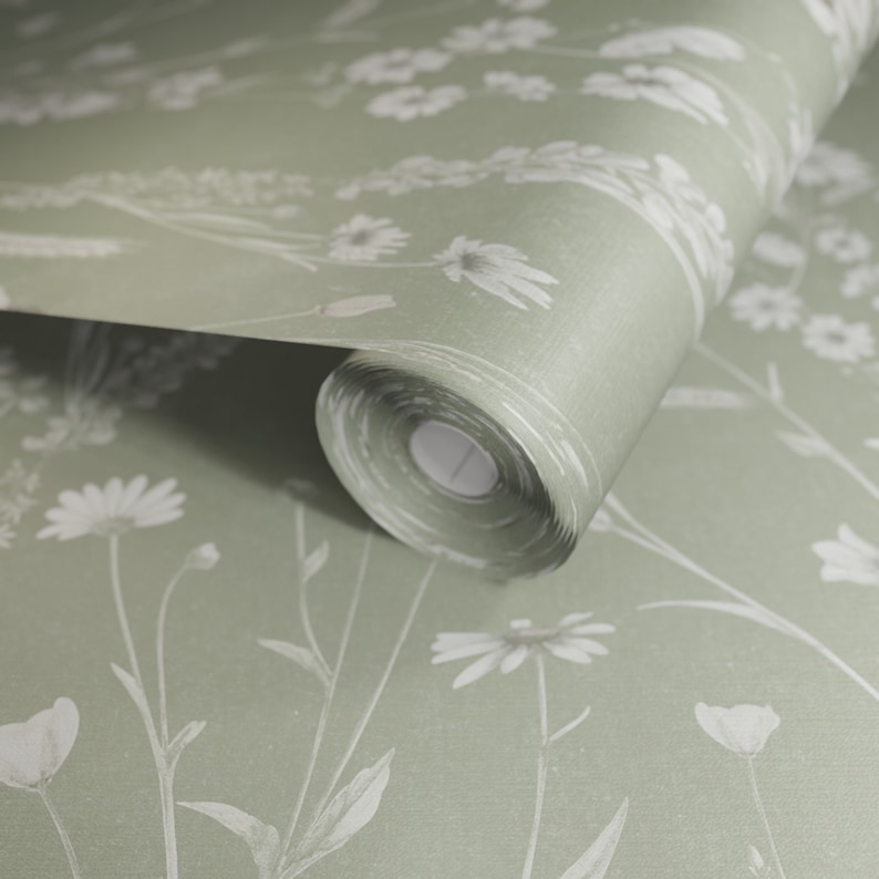 May include: A roll of green wallpaper with a white floral pattern. The wallpaper features a delicate design of white flowers and leaves on a sage green background.