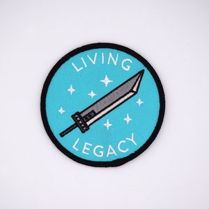 May include: Round patch with a teal background, black border, and the words "LIVING LEGACY" in white. A gray and silver sword is in the center, with white star accents. The patch is likely for clothing or accessories.