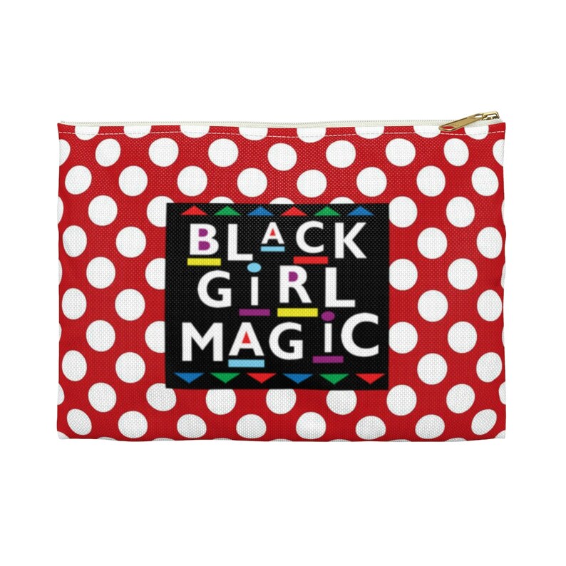 Peut inclure: Pochette rouge &agrave; fermeture &eacute;clair avec des pois blancs et un rectangle noir avec le texte "BLACK GIRL MAGIC" en lettres color&eacute;es.