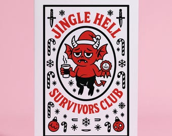 May include: A white greeting card with a red and black illustration. The illustration features a red devil holding a coffee cup and a badge that says "I Tried". The text on the card reads "Jingle Hell Survivors Club".