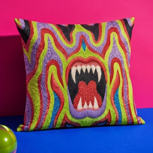 May include: A square throw pillow featuring a vibrant, multi-colored abstract pattern of wavy lines in shades of lime green, purple, red, and blue. The center displays a stylized, open mouth with sharp white teeth and a textured red tongue.