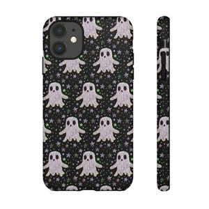 Black phone case featuring white textured ghost pattern with multicolored star accents. Kawaii-style ghosts with simple black eyes on dark background.