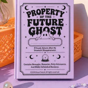 A 5 by 7 inch hardcover journal with a matte pastel purple cover and black printed graphics. The front features a retro inspired illustration of a white ghost character. One design shows the ghost holding a locked book flanked by a lit candle and a skeleton key with text reading Notes For My Future Ghost. The other shows the ghost peeking over a blank label with text reading Property Of The Future Ghost. Both include crescent moons, four point stars, and vintage decorative border frames.