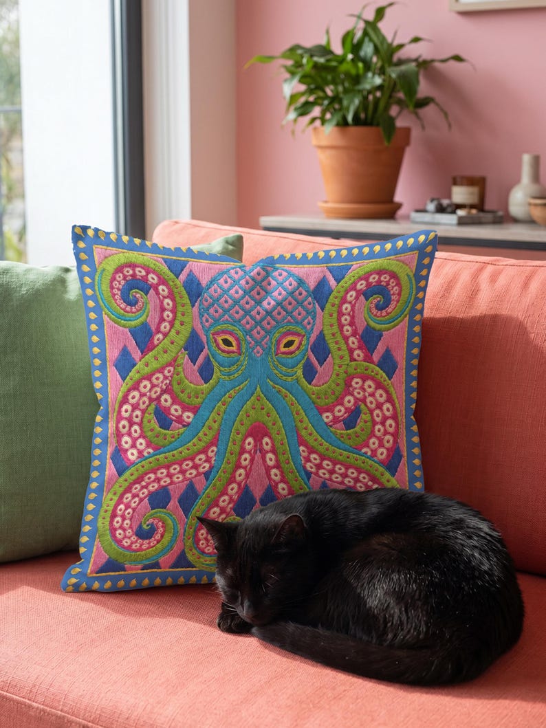 A square decorative throw pillow cover featuring a highly symmetrical bright octopus design. The octopus has a turquoise blue body with a diamond patterned head and eight curled tentacles detailed in bright pink and lime green. The background is a repeating diamond argyle pattern in royal blue and light pink. The artwork is a flat two dimensional print that mimics the textured look of intricate crewelwork embroidery. The pillow features a hidden zipper on the bottom edge. No insert included.