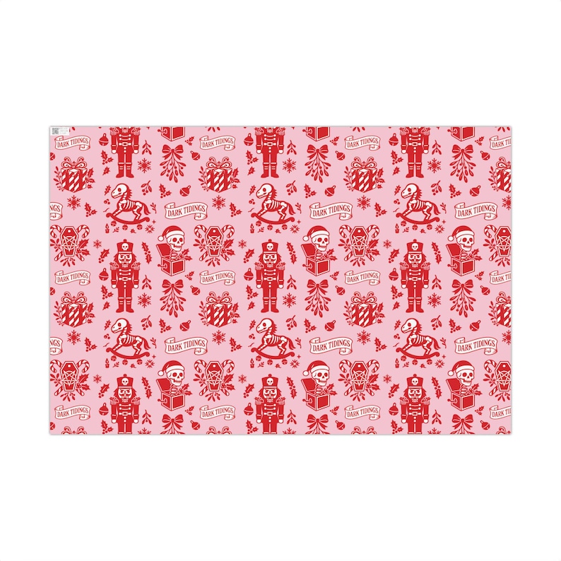 Premium satin finish wrapping paper featuring a repeating pastel goth pattern on a pink background. The design showcases a playful yet spooky aesthetic with high-contrast skeleton nutcrackers, skull jack-in-the-boxes, and rocking horse skeletons in soft pinks, and reds. The paper texture appears semi-glossy. Shown in three available sizes including sheets and rolls, specifically 29 inches wide, suitable for wrapping gifts for holidays, birthdays, or gothic themed occasions.