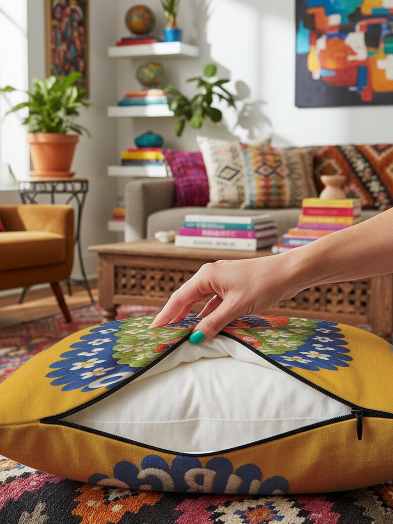 A square throw pillow featuring a vibrant Virgo zodiac design on a golden mustard yellow background. The central illustration shows a terracotta-skinned figure with green hair adorned with white daisies. Blue leaf motifs are printed on the figure’s chest. The word "VIRGO" appears in white bubble letters at the top. The entire design is framed by a royal blue scalloped border, featuring a high-fidelity trompe-l'œil print that mimics 3D embroidery.