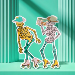 Könnte beinhalten: Zwei Skelettfiguren, die Hüte und Rollschuhe tragen. Ein Skelett hält eine alte Boombox. Die Skelette sind gelb und rosa mit schwarzen Umrissen.