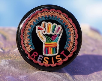 Botón de protesta con pin de resistencia: insignia de solapa activista por la justicia social y una declaración política.