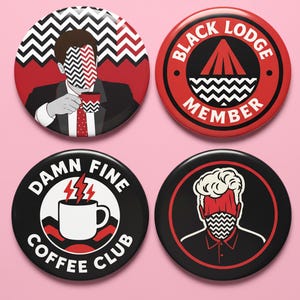 May include: Four circular pin badges on a pink backdrop. The badges feature illustrations and text, including "BLACK LODGE MEMBER" and "DAMN FINE COFFEE CLUB". The colour scheme includes black, red, and white.
