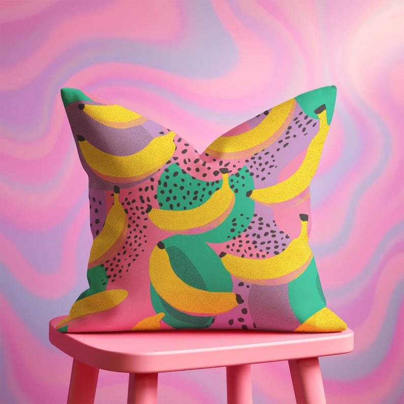 Square pillowcase featuring a bold and playful banana print in a vibrant pop art style. The design includes bright yellow bananas layered over a backdrop of pink, purple, green, and teal with dotted and speckled textures for a dynamic, retro-inspired look. Made of smooth fabric with crisp edges and a snug fit, the pillowcase showcases a saturated, high-contrast palette perfect for maximalist or dopamine decor. Pillow cover only; insert not included.
