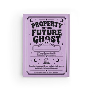 A 5 by 7 inch hardcover journal with a matte pastel purple cover and black printed graphics. The front features a retro inspired illustration of a white ghost character. One design shows the ghost holding a locked book flanked by a lit candle and a skeleton key with text reading Notes For My Future Ghost. The other shows the ghost peeking over a blank label with text reading Property Of The Future Ghost. Both include crescent moons, four point stars, and vintage decorative border frames.