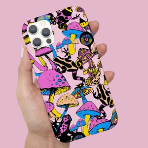May include: A pink phone case featuring a colourful design of mushrooms and frogs. The case has a black camera lens and a white background.