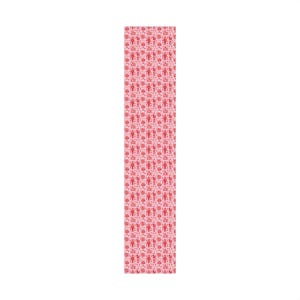 Premium satin finish wrapping paper featuring a repeating pastel goth pattern on a pink background. The design showcases a playful yet spooky aesthetic with high-contrast skeleton nutcrackers, skull jack-in-the-boxes, and rocking horse skeletons in soft pinks, and reds. The paper texture appears semi-glossy. Shown in three available sizes including sheets and rolls, specifically 29 inches wide, suitable for wrapping gifts for holidays, birthdays, or gothic themed occasions.