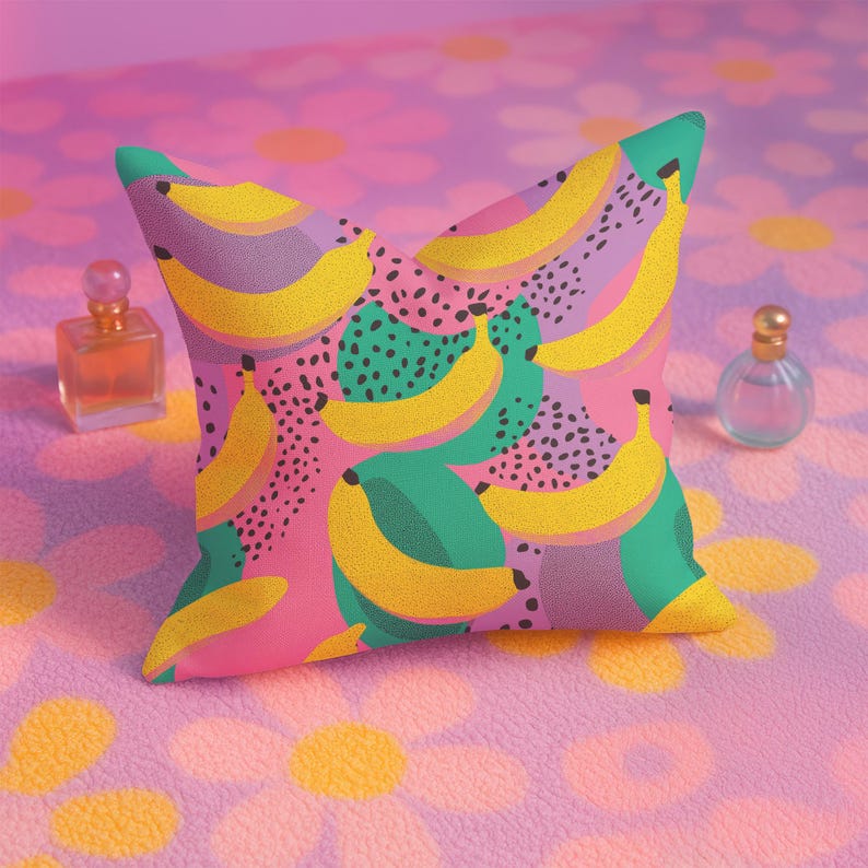 Square pillowcase featuring a bold and playful banana print in a vibrant pop art style. The design includes bright yellow bananas layered over a backdrop of pink, purple, green, and teal with dotted and speckled textures for a dynamic, retro-inspired look. Made of smooth fabric with crisp edges and a snug fit, the pillowcase showcases a saturated, high-contrast palette perfect for maximalist or dopamine decor. Pillow cover only; insert not included.