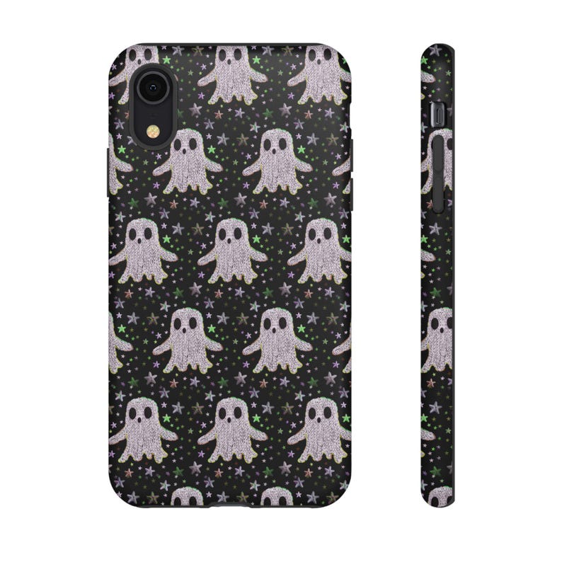 Black phone case featuring white textured ghost pattern with multicolored star accents. Kawaii-style ghosts with simple black eyes on dark background.