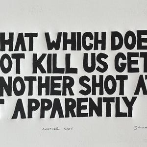 Könnte beinhalten: Schwarz-weißer Textildruck mit dem Zitat "That which does not kill us gets another shot at it apparently." Der Druck ist signiert mit "JMILLARD '25" und trägt den Titel "Another Shot".