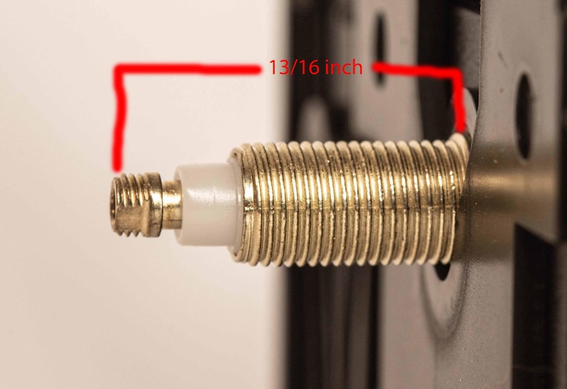 May include: A close-up of a gold-colored metal threaded rod with a white plastic piece. The rod is 13/16 inch long.