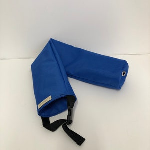 Pu&ograve; includere: Un tubo in tessuto blu brillante dal design piegato, dotato di una cinghia in nylon nero con fibbia in plastica, un occhiello metallico argentato a un'estremit&agrave; e una piccola etichetta rettangolare beige con la scritta J.A.Fashions sul lato.