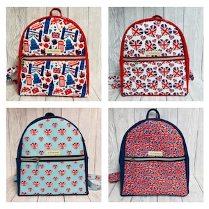 May include: Four backpacks with British-themed designs. The top left backpack has a red border and features London landmarks. The top right backpack has a red border and Union Jack patterns. The bottom left backpack has a blue border and heart-shaped Union Jack patterns. The bottom right backpack has a blue border and Union Jack patterns.