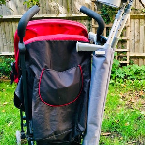 Pu&ograve; includere: Un passeggino rosso e nero con una tasca portaoggetti nera con bordo rosso. Un supporto in tessuto grigio per stampelle &egrave; fissato lateralmente, contenente un paio di stampelle antibrachiali grigie con impugnature e bracciali neri. Etichetta.