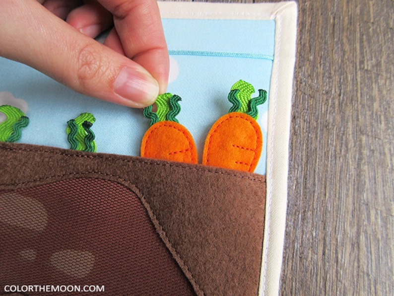 May include: A felt play set with a brown patch of felt representing dirt.  There are three green felt carrot tops and two orange felt carrots.  The carrots are attached with velcro and can be removed.