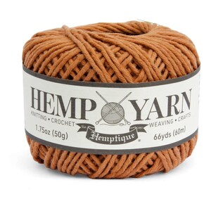 K&ouml;nnte beinhalten: Ein Kn&auml;uel braunes Hanfgarn mit einem wei&szlig;en Etikett. Auf dem Etikett steht "HEMP YARN" mit "KNITTING CROCHET" und "WEAVING CRAFTS" darunter. Es gibt auch die Angaben "1.75oz (50g)" und "66yds (60m)".