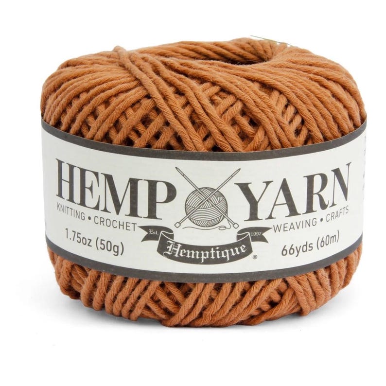 K&ouml;nnte beinhalten: Ein Kn&auml;uel braunes Hanfgarn mit einem wei&szlig;en Etikett. Auf dem Etikett steht "HEMP YARN" mit "KNITTING CROCHET" und "WEAVING CRAFTS" darunter. Es gibt auch die Angaben "1.75oz (50g)" und "66yds (60m)".