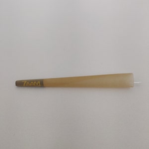 May include: A brown, thin, paper cone with a gold 7AM logo printed on it.