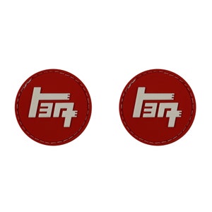May include: Two red round patches with white Toyota logos. The logos are stylized and resemble the Japanese characters for "Toyota".