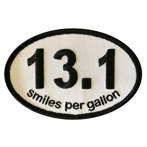 May include: White oval patch with black embroidered text. The text reads "13.1 smiles per gallon".