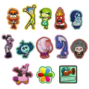 Può includere: Una collezione di ciondoli colorati di personaggi dei cartoni animati, tra cui Gioia, Tristezza, Rabbia e Paura. I ciondoli presentano varie forme e design, con un bordo cucito. Sono inclusi anche un fiore e un quadrato con la scritta "FOG HORNS".