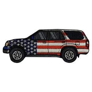 Puede incluir: Un parche bordado de un SUV rojo, blanco y azul con un diseño de bandera estadounidense. El SUV está de perfil y la bandera está en el lateral del vehículo.