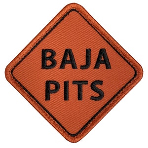 May include: Orange diamond-shaped patch with black stitching and the text "BAJA PITS" in black.