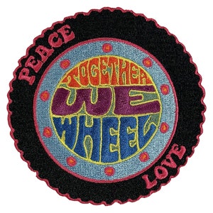 May include: A black and pink circular patch with the words "Peace" and "Love" on the top and bottom. The centre of the patch has a blue, yellow, orange, and purple design with the words "Together We Wheel".