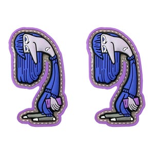 May include: Two identical rubberized patches featuring a cartoon character with long blue hair, a pale face, and a blue outfit. The character is hunched over, holding a small purple rectangular object, and is outlined in a thick purple border.