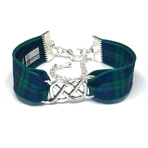 May include: A green and blue tartan ribbon bracelet with a silver Celtic knot charm and a silver chain closure.