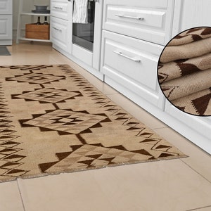 May include: A beige and brown geometric patterned runner rug with a fringed edge. The rug is folded in a circle in the upper right corner of the image.