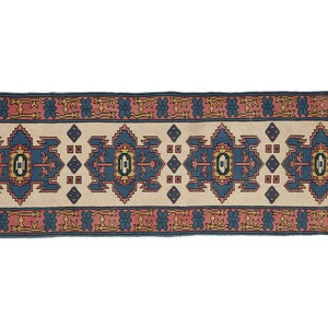 K&ouml;nnte beinhalten: Ein langer, schmaler Teppich mit traditionellem persischem Design. Der Teppich hat einen cremefarbenen Hintergrund mit einem blauen, roten und gelben Muster. Der Teppich ist perfekt, um jedem Raum einen Hauch von traditionellem Stil zu verleihen.