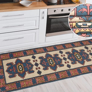 K&ouml;nnte beinhalten: Ein beige-blauer K&uuml;chenl&auml;ufer mit rotem Rand. Der L&auml;ufer hat ein traditionelles Design mit geometrischen Formen und floralen Motiven. Der L&auml;ufer ist in der oberen rechten Ecke des Bildes gefaltet, wodurch das Detail des Musters sichtbar wird.