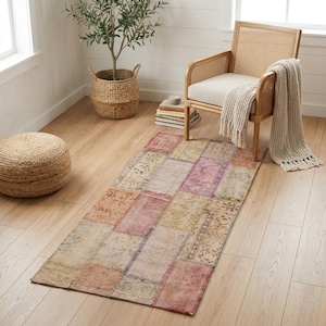 May include: A rectangular area rug featuring a patchwork design of various faded floral and geometric patterns in muted shades of pink, orange, beige, and grey. The rug is constructed from multiple rectangular sections stitched together.