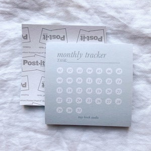May include: A light blue monthly tracker with a white border and white numbers. The tracker is labeled "monthly tracker" and "TASK:" at the top. The numbers 1-31 are arranged in a grid format. The bottom of the tracker says "tiny birch studio".