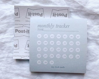 May include: A light blue monthly tracker with a white border and white numbers. The tracker is labeled "monthly tracker" and "TASK:" at the top. The numbers 1-31 are arranged in a grid format. The bottom of the tracker says "tiny birch studio".