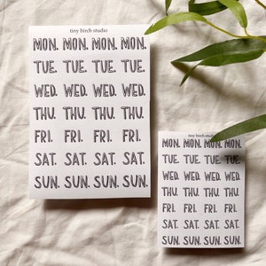 May include: Two sheets of stickers with the days of the week written in black on a white background. The text on the stickers reads "MON. MON. MON. MON. TUE. TUE. TUE. TUE. WED. WED. WED. WED. THU. THU. THU. THU. FRI. FRI. FRI. FRI. SAT. SAT. SAT. SAT. SUN. SUN. SUN. SUN."