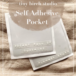 May include: Two clear self-adhesive pockets with white text that reads "POCKET FULL OF SUNSHINE" and "PLANNER STUFF". The pockets are rectangular with rounded corners and are on a beige background. The text "tiny birch studio" and "Self Adhesive Pocket" are at the top.