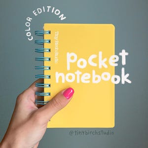 May include: A yellow pocket notebook with light blue spiral binding. The cover features the text "Tiny Birch Studio" vertically, "COLOR EDITION" in an arc, and "pocket notebook" in large white script. The brand handle "@tinybirchstudio" is at the bottom.