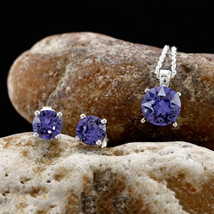 Puede incluir: Un conjunto de joyas de plata con piedras preciosas p&uacute;rpuras. El conjunto incluye un collar con colgante y un par de pendientes.