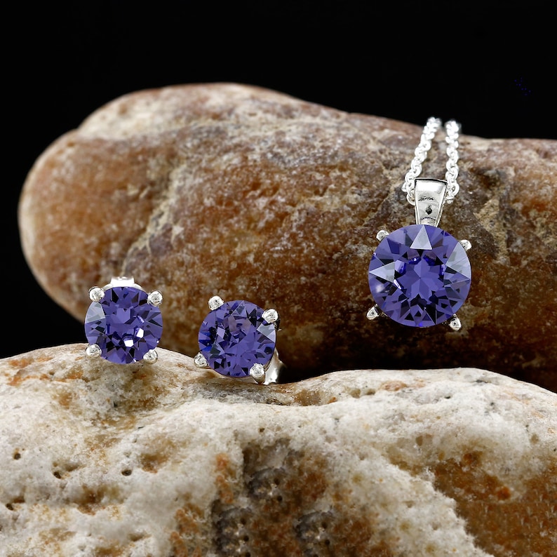 Puede incluir: Un conjunto de joyas de plata con piedras preciosas p&uacute;rpuras. El conjunto incluye un collar con colgante y un par de pendientes.